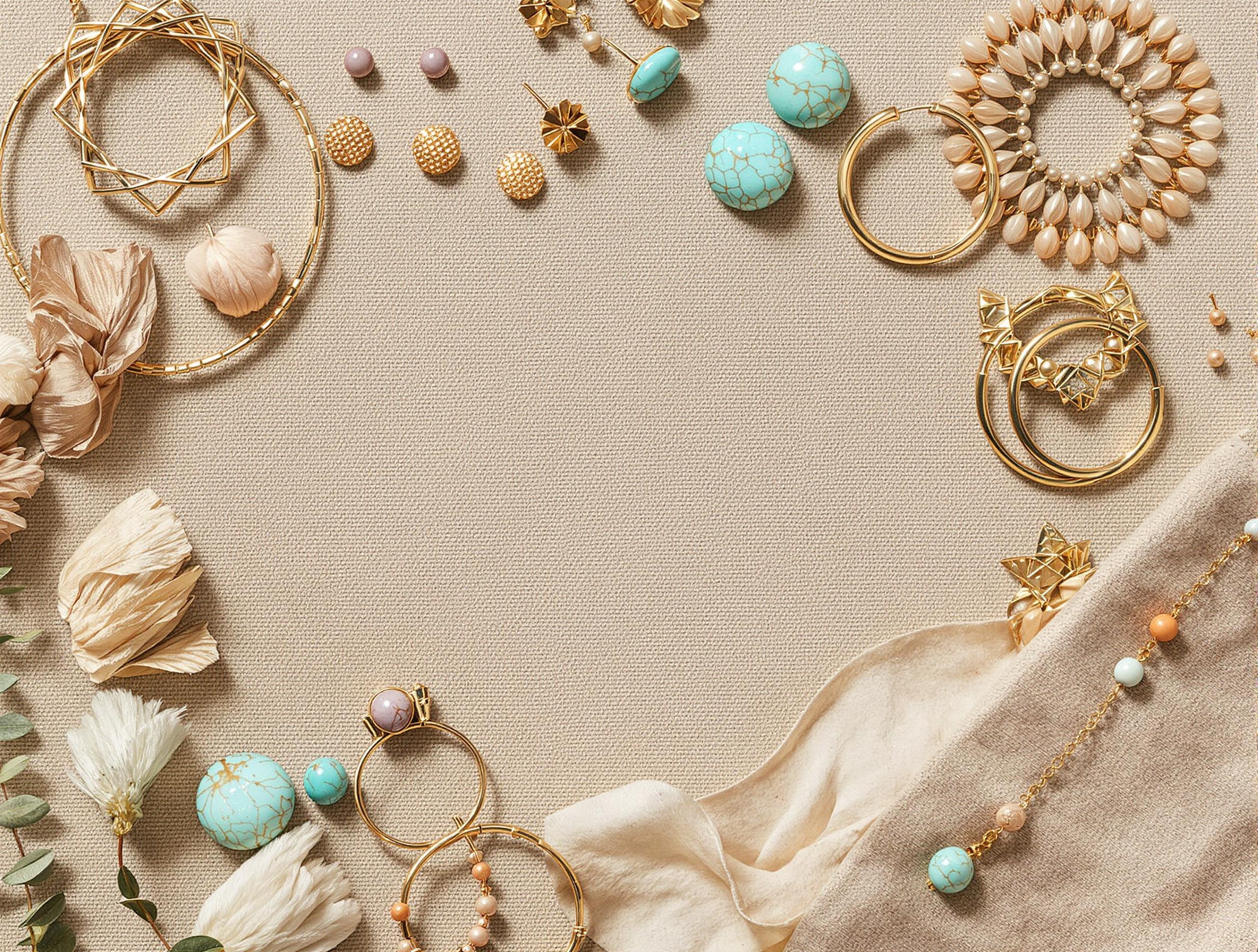 Créoles bohèmes, clous sculptés, anneaux dorés, pompons – flat lay bohème