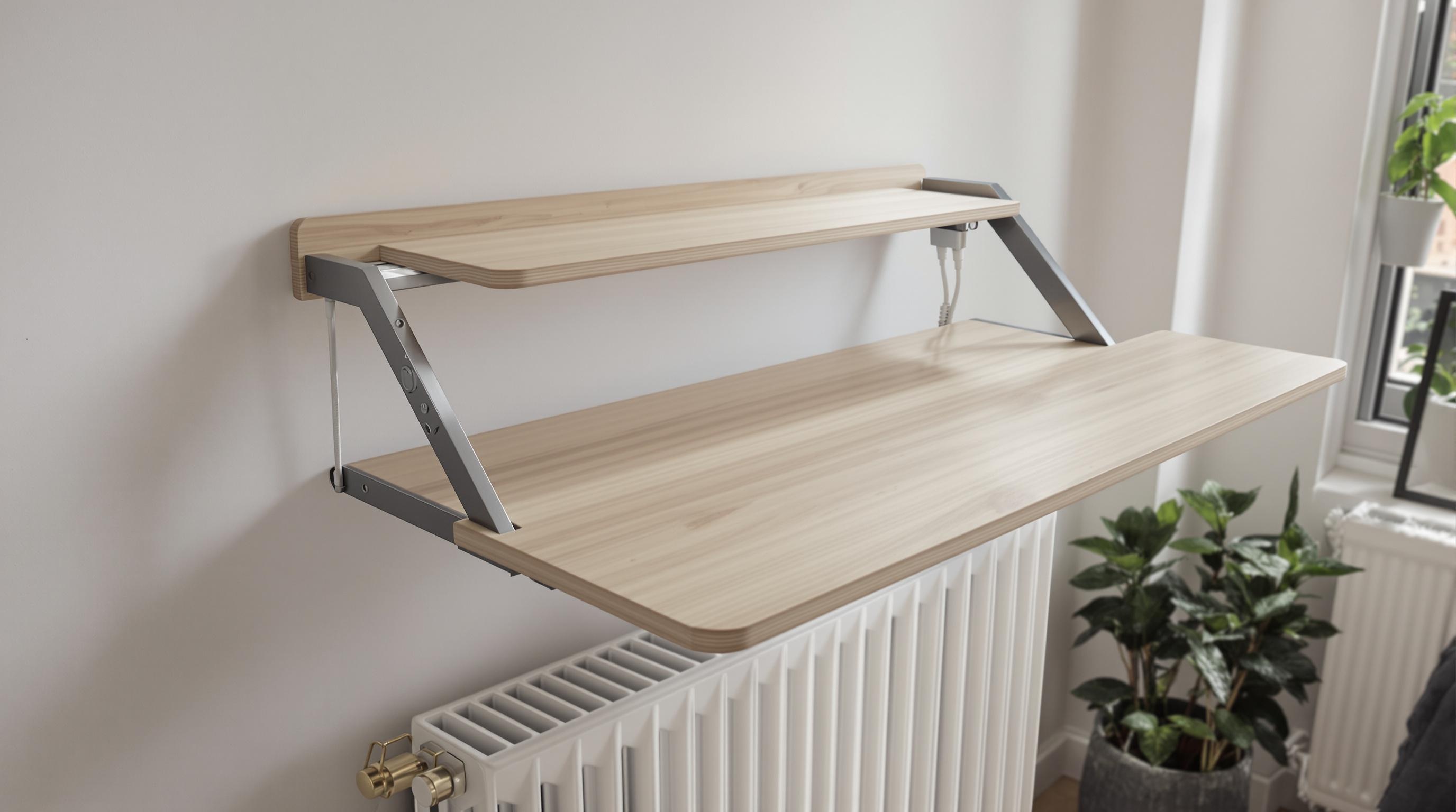 Bureau d’appoint rabattable au-dessus d’un radiateur dans un studio : plateau bois clair, fixations métal design, passage de câble dissimulé, ambiance gain de place, style minimaliste moderne.