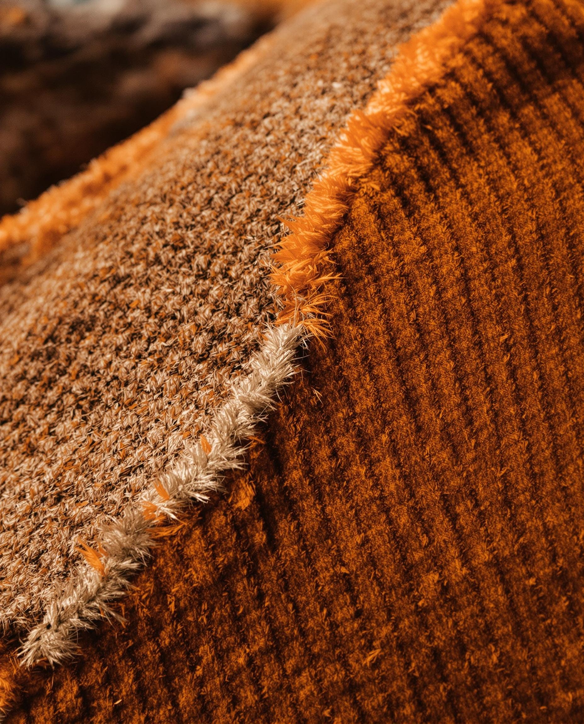 Texture velours côtelé orange brûlé et laine bouclée vintage.