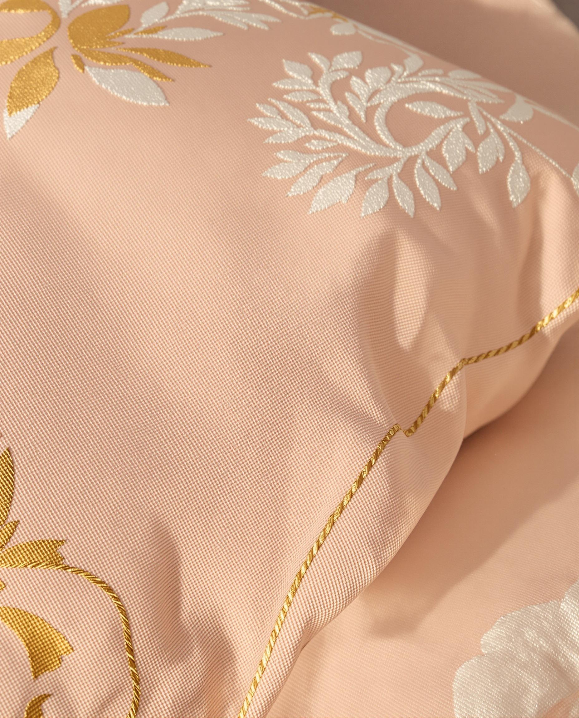 Coussin couleur pêche avec broderies dorées élégantes