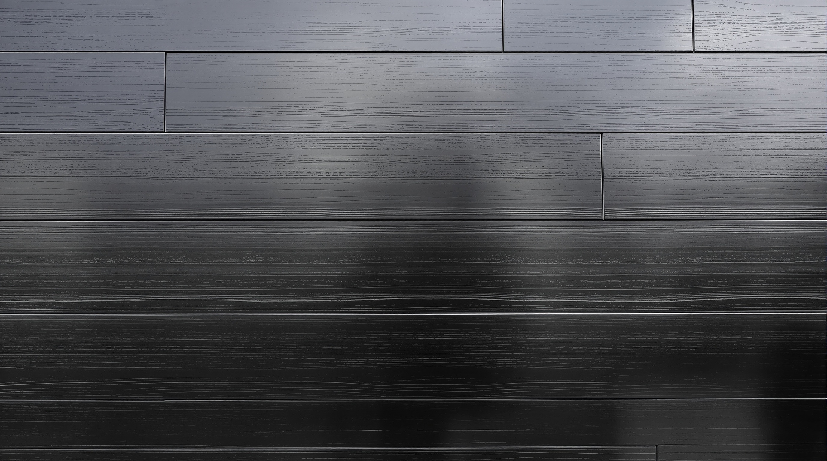 Façade extérieure noire contemporaine parfaitement entretenue avec traces naturelles de patine.