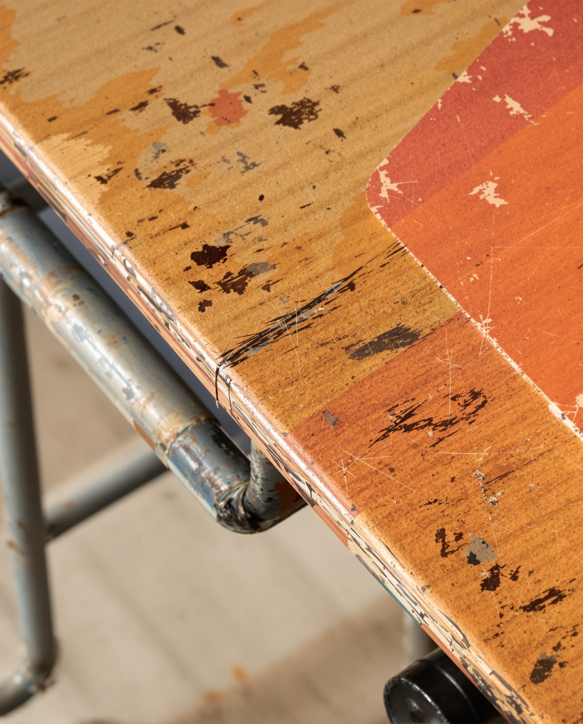 Détail bois massif patiné, piètement métallique tubulaire et Formica coloré