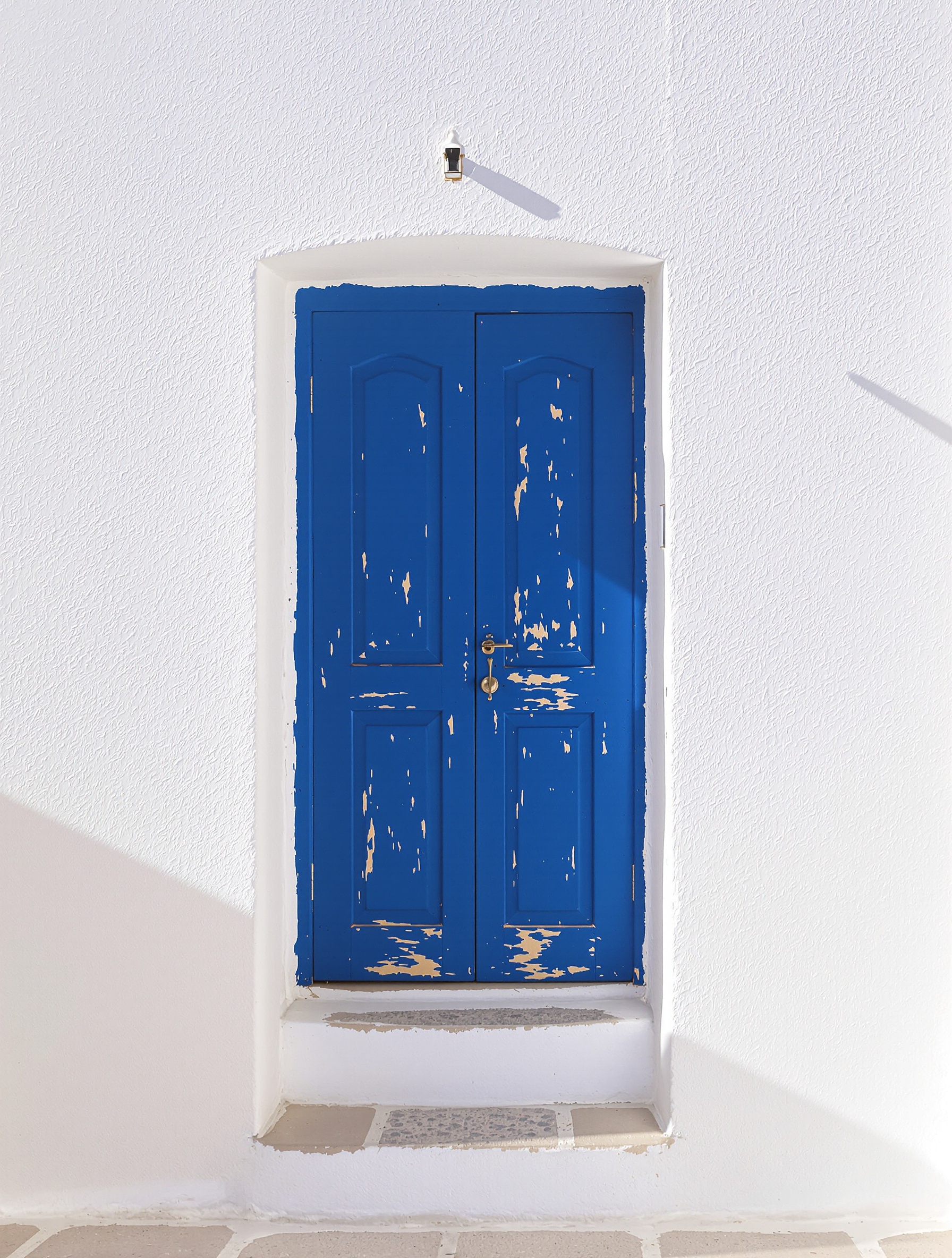 Porte bleue intense sur mur blanc à Santorin