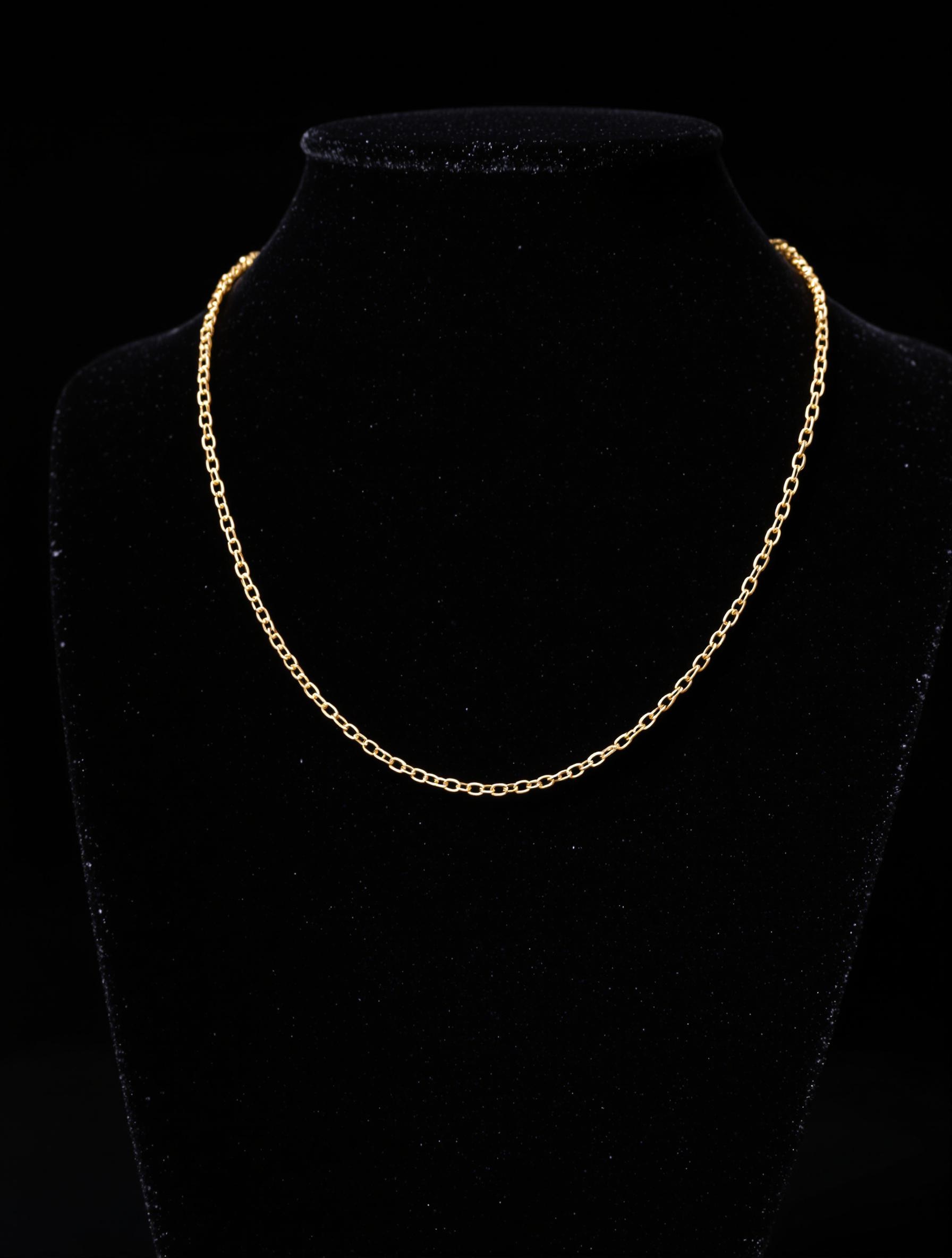 Sautoir minimaliste en or 18 carats sur présentoir en velours noir